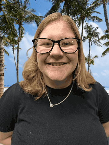 Young woman on holiday with palm trees in background